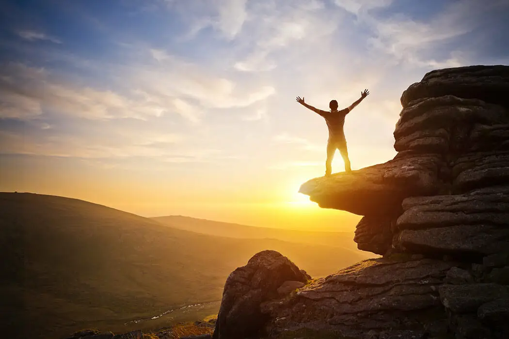 Person standing on summit in the sun