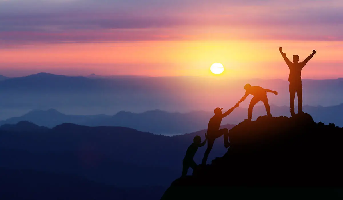 Travelers celebrating achievement at top of mountain