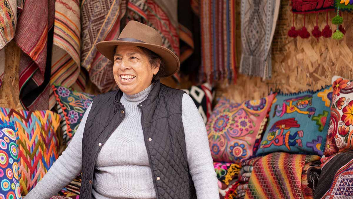 An indigenous woman sells goods in Peru. Supporting local businesses is an overtourism solution