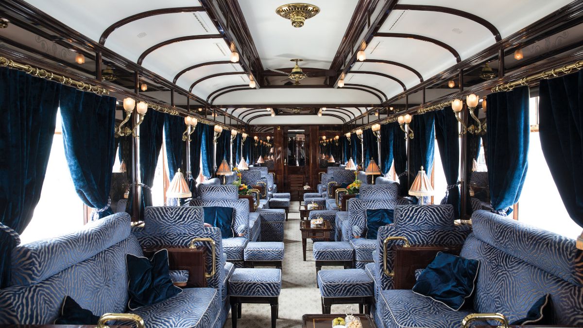 Luxury bar in a train car with blue couches and tables