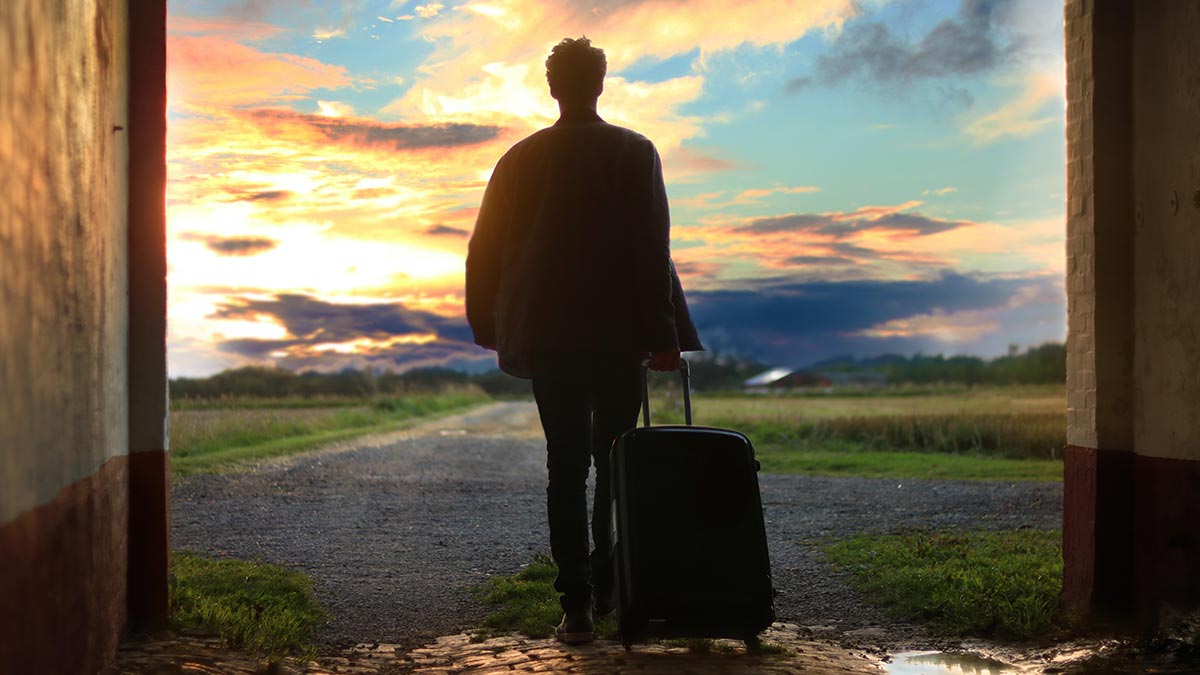 Sustainable traveler holding suitcase and looking off into the future