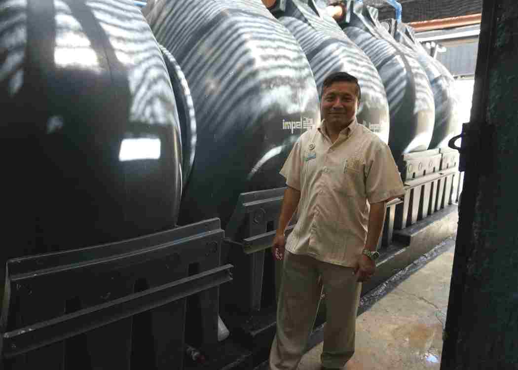 Wastewater treatment plant worker, Azul Beach Nehemias Azuel Uyub, stands next to the treatment tanks at the facility in Roatán