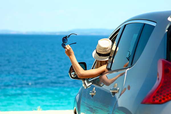 Woman in rental car traveling on vacation