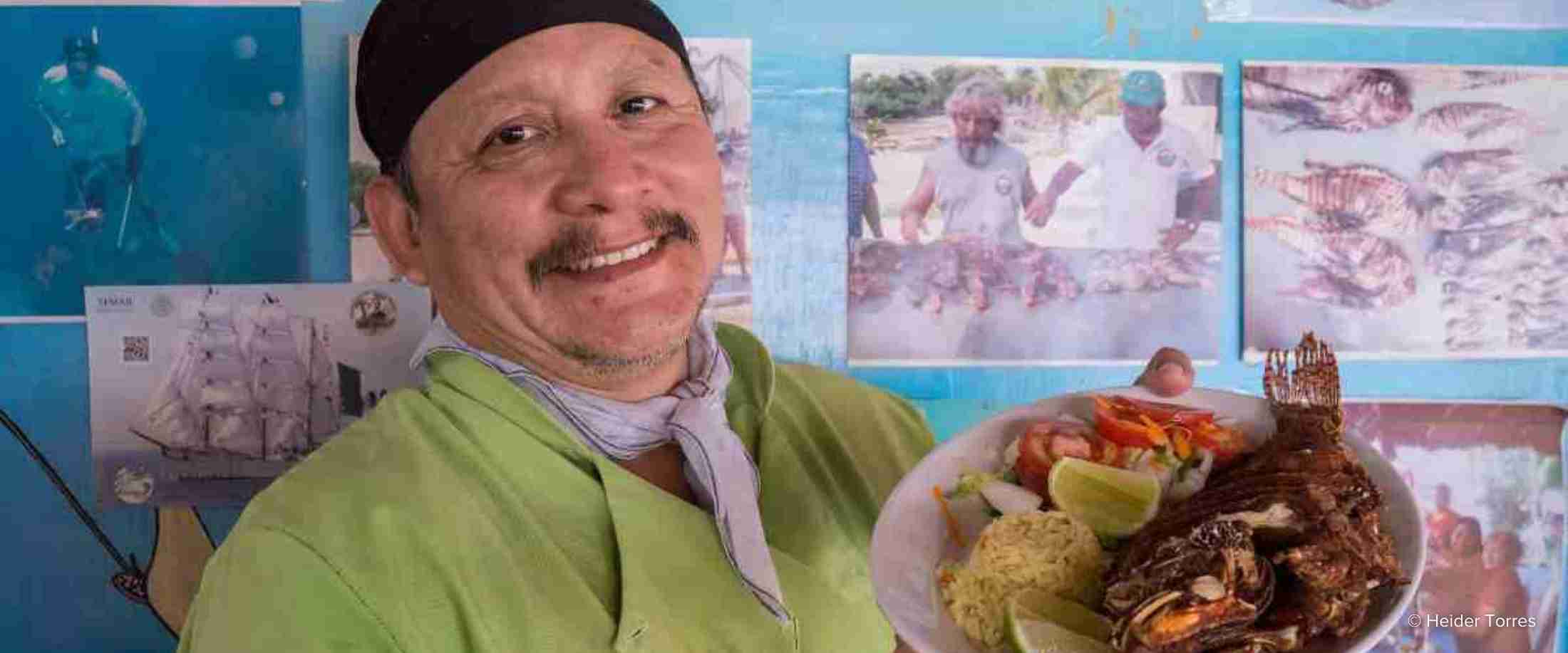 Silviano Puc Quijano, a cook at Bahia del Caribe Restaurant, shows off a lionfish menu item. This restaurant is a part of the Cozumel Fishing Cooperative.